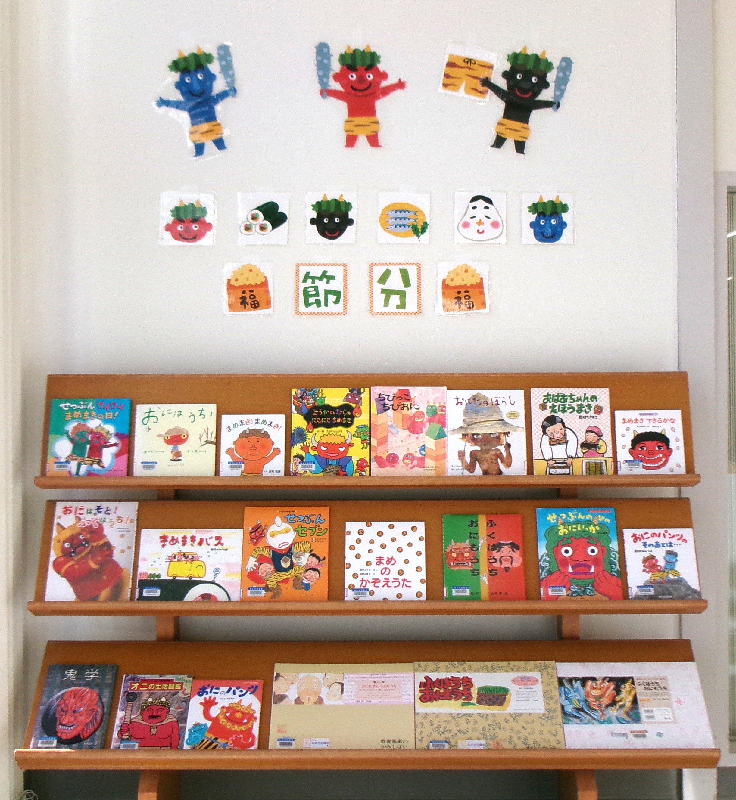 節分で飾られた壁面と、節分の絵本や紙芝居などが並べられた棚